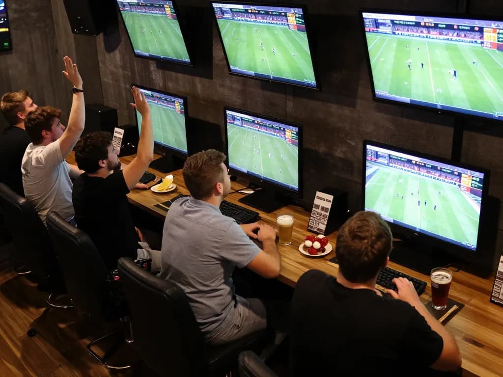 Enjoying live betting action at Lương Sơn TV with friends, excitement surrounding multiple screens and bets.